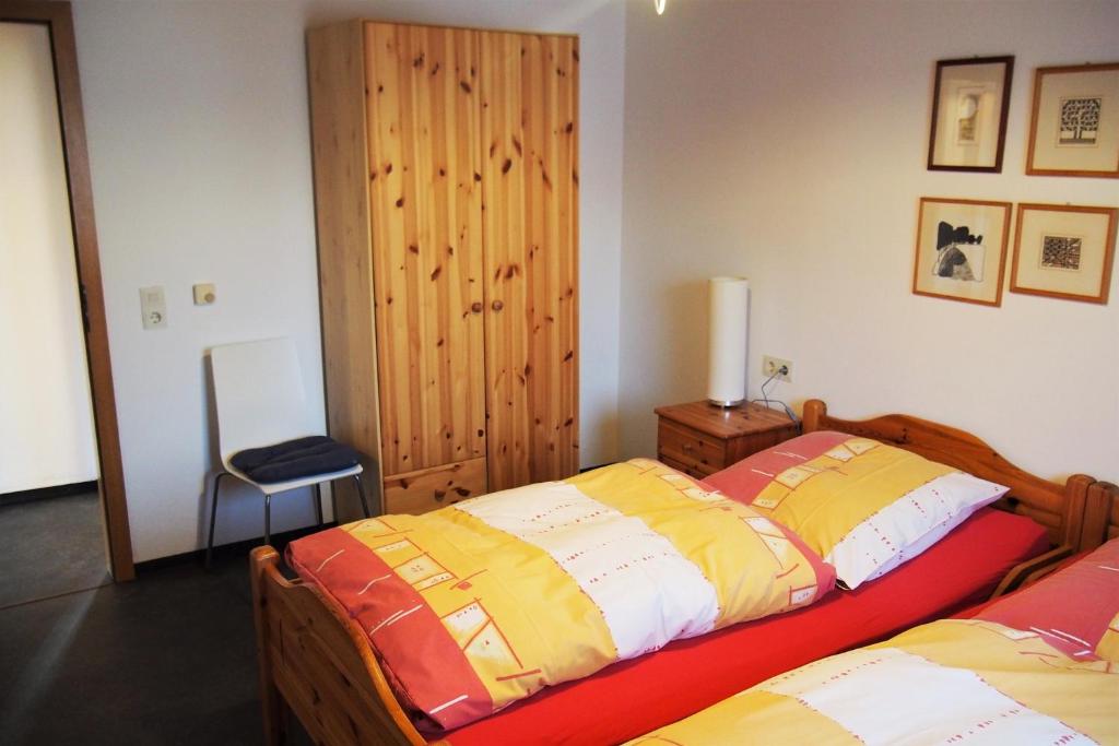 1 Schlafzimmer mit 2 Betten und einem Stuhl in der Unterkunft Ferienwohnung Seidenfaden in Karlstadt