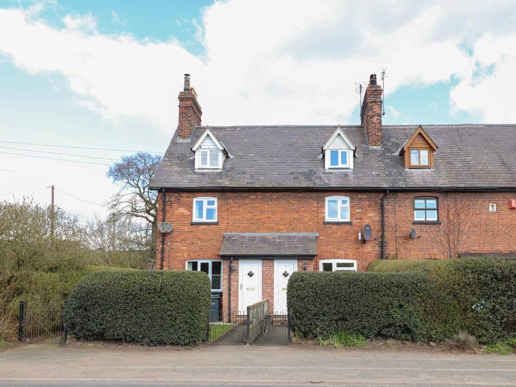 a large red brick house with a white garage at 2 Organsdale Cottages in Kelsall Hill