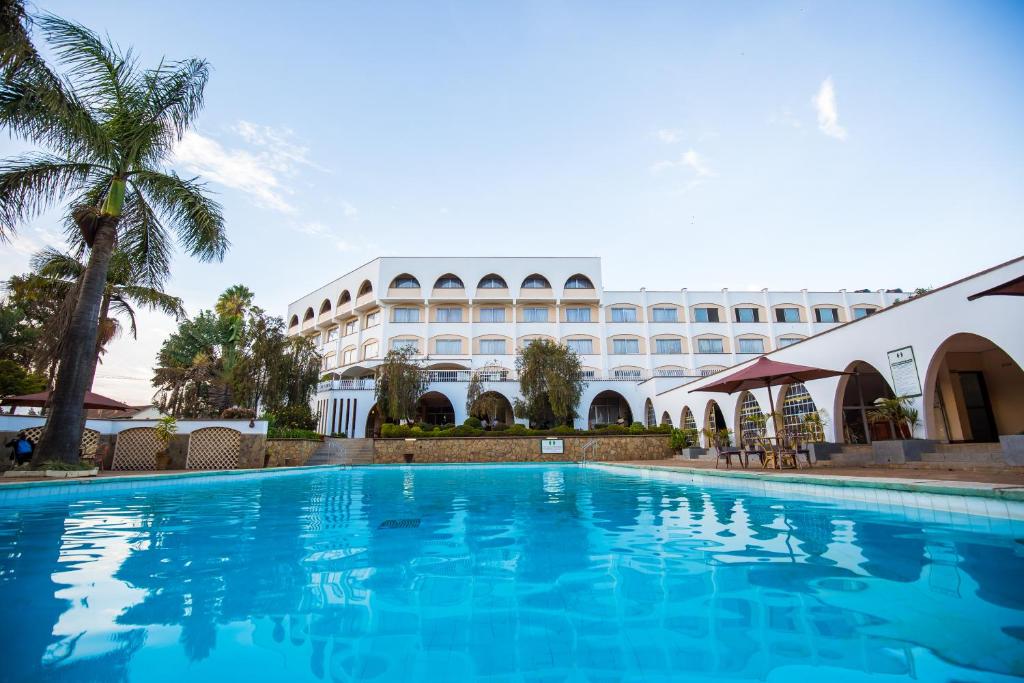 a swimming pool in front of a building at Sirikwa Hotel in Eldoret