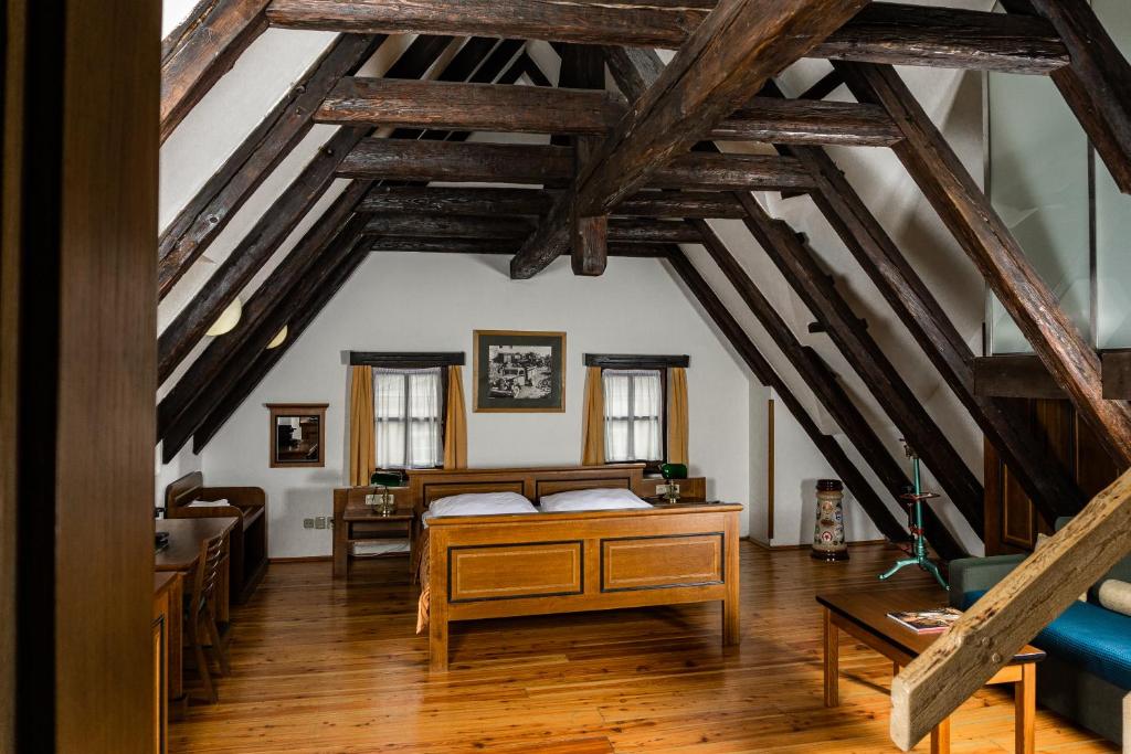 een slaapkamer met een bed in een kamer met houten plafonds bij U Medvidku-Brewery Hotel in Praag