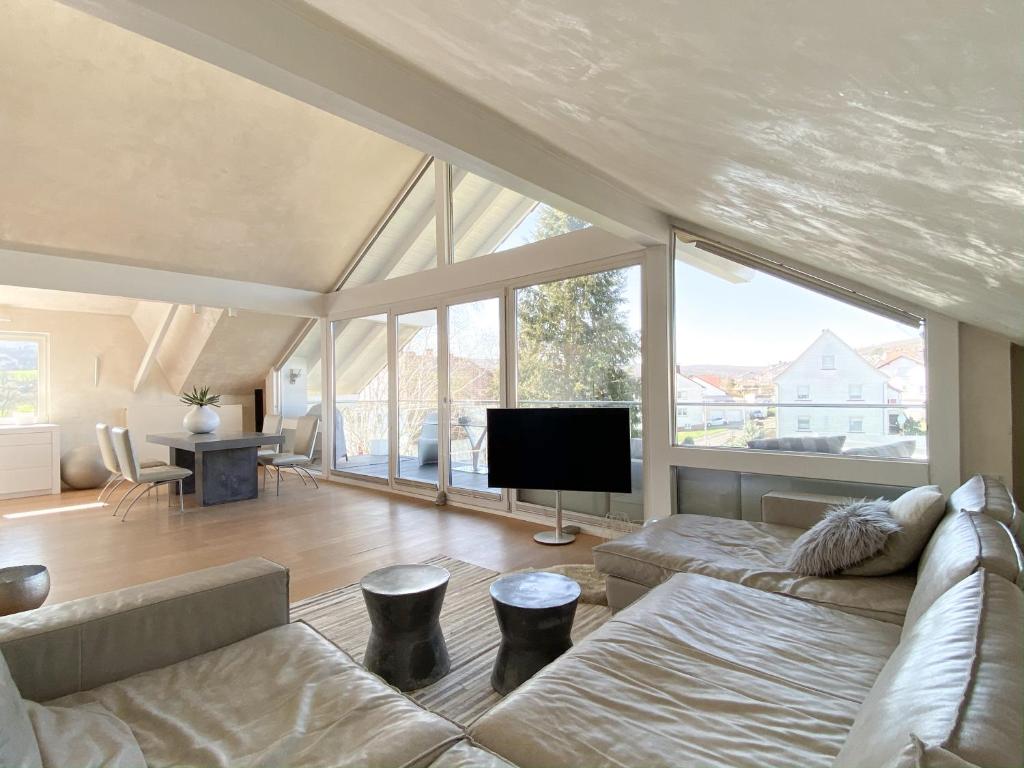a living room with a couch and a flat screen tv at Das Penthouse von Loftalive in Lollar