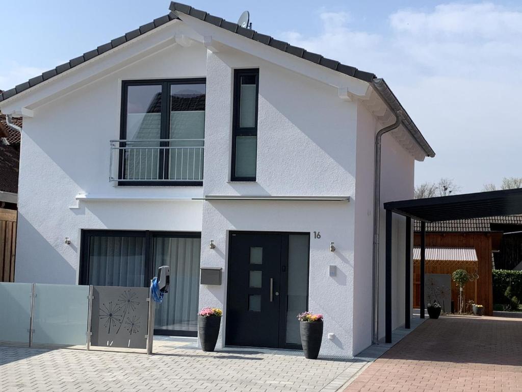 a white house with a black door at Ferienwohnung Susanne in Bad Krozingen