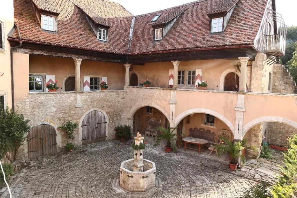 una casa antigua con un patio con una fuente en Geyer-Schloss Reinsbronn, en Creglingen