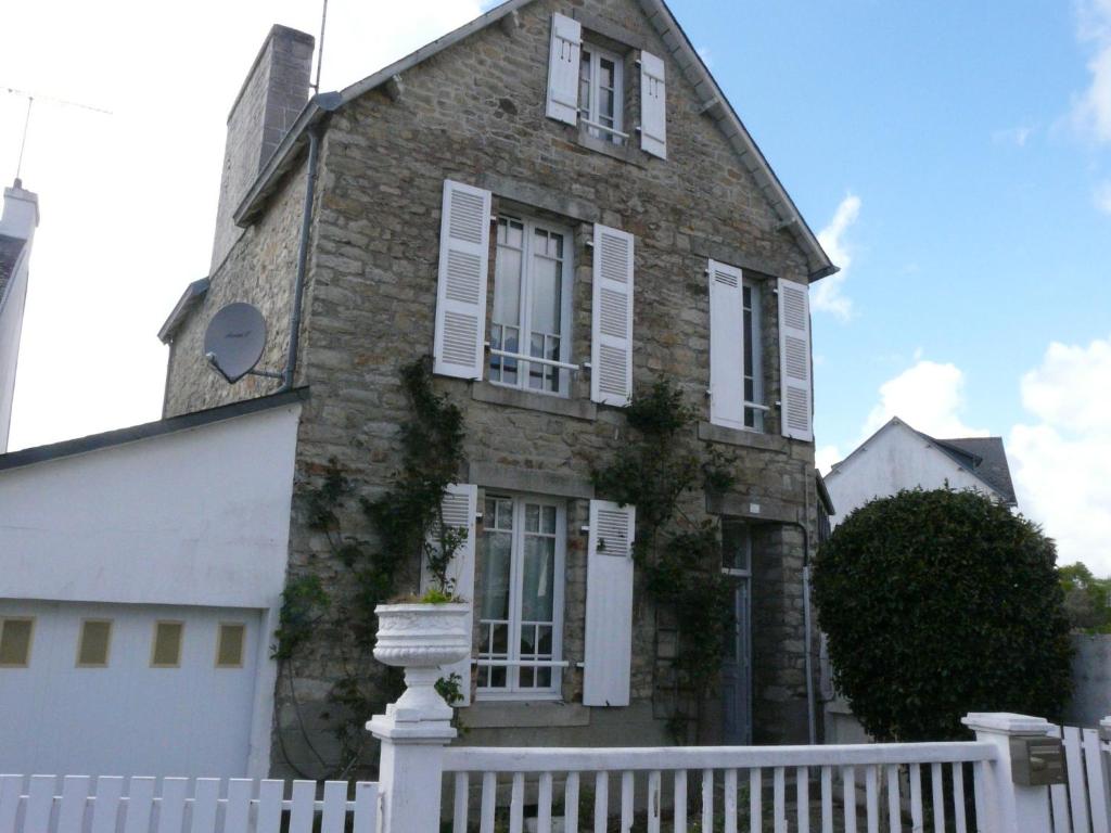 une vieille maison en briques avec une clôture blanche dans l'établissement Ker Corentine, maison de charme à Benodet, jardin, à Bénodet