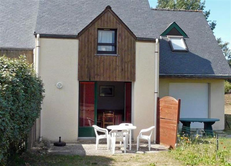 une maison avec une table et des chaises devant elle dans l'établissement Village d'Armor, maison à Erdeven, à Erdeven