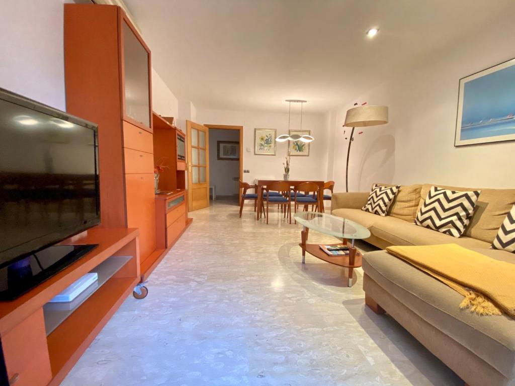 uma sala de estar com um sofá e uma televisão de ecrã plano em Apartment Rambla Tarragona Free parking em Tarragona