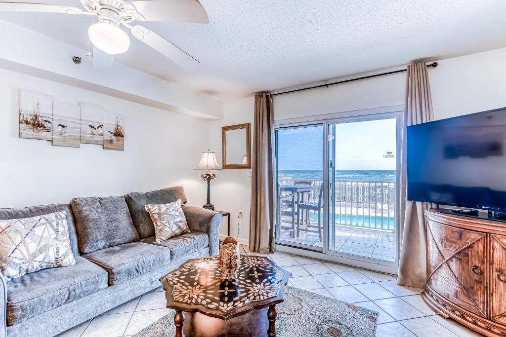 a living room with a couch and a flat screen tv at Four Winds in Orange Beach
