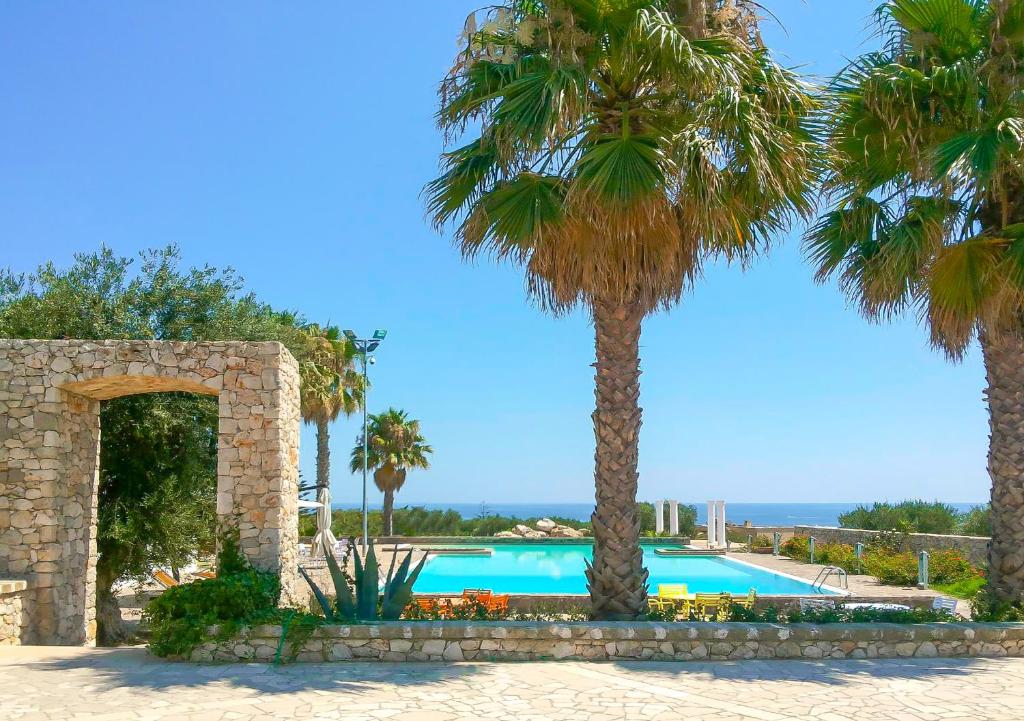 uma piscina com palmeiras num resort em Picchio Hotel Pescoluse em Marina di Pescoluse