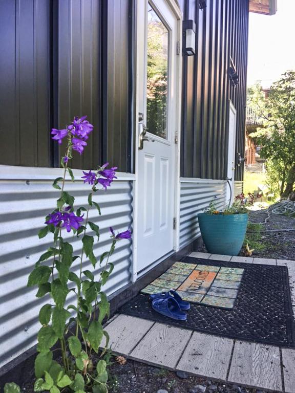 a door to a house with purple flowers on the porch at The Vue B&B in Seward