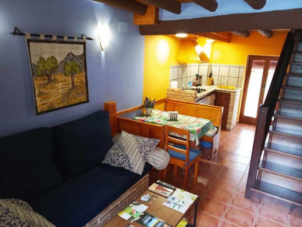 a living room with a table and a kitchen at La caseta de Pedris in Valderrobres