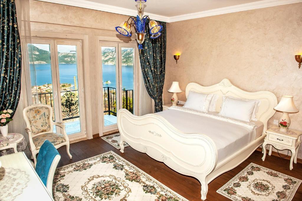 ein Schlafzimmer mit einem großen weißen Bett und einem Balkon in der Unterkunft Swan Lake Hotel - Adult Only in Selimiye