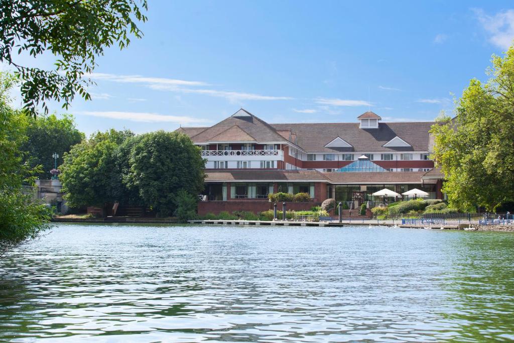 un grand bâtiment au bord d'un lac dans l'établissement Crowne Plaza Reading, à Reading