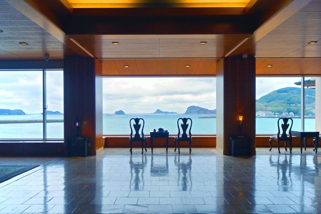 a row of chairs in a room with a view of the ocean at IKI RETREAT by Onko Chishin in Iki