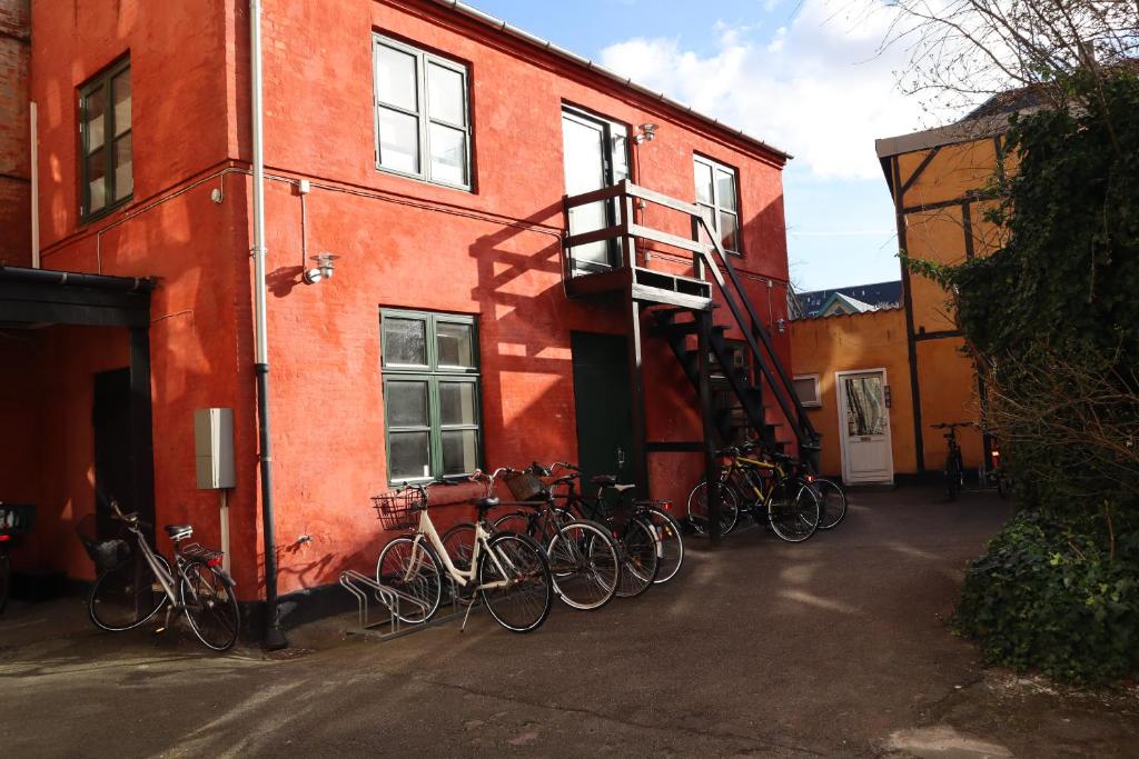 a group of bikes parked on the side of a building at Charming Red Courtyard Apartment in Copenhagen