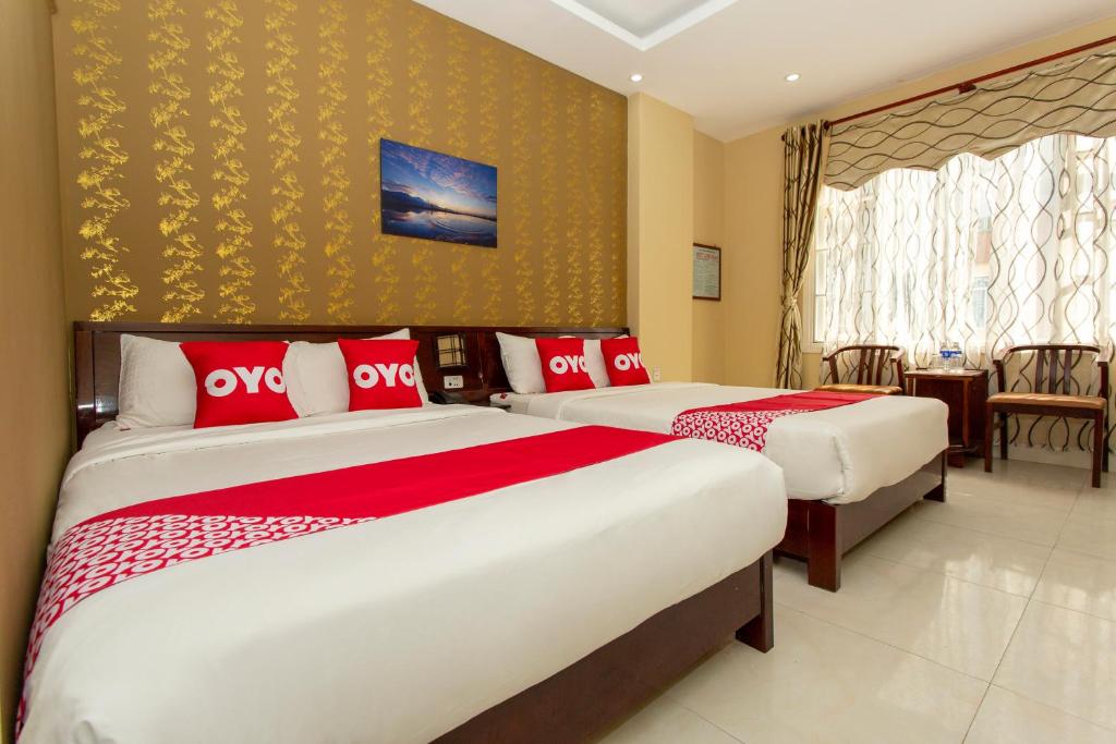 峴港的住宿－Phuc Long Hotel，一间卧室配有两张带红白色枕头的床
