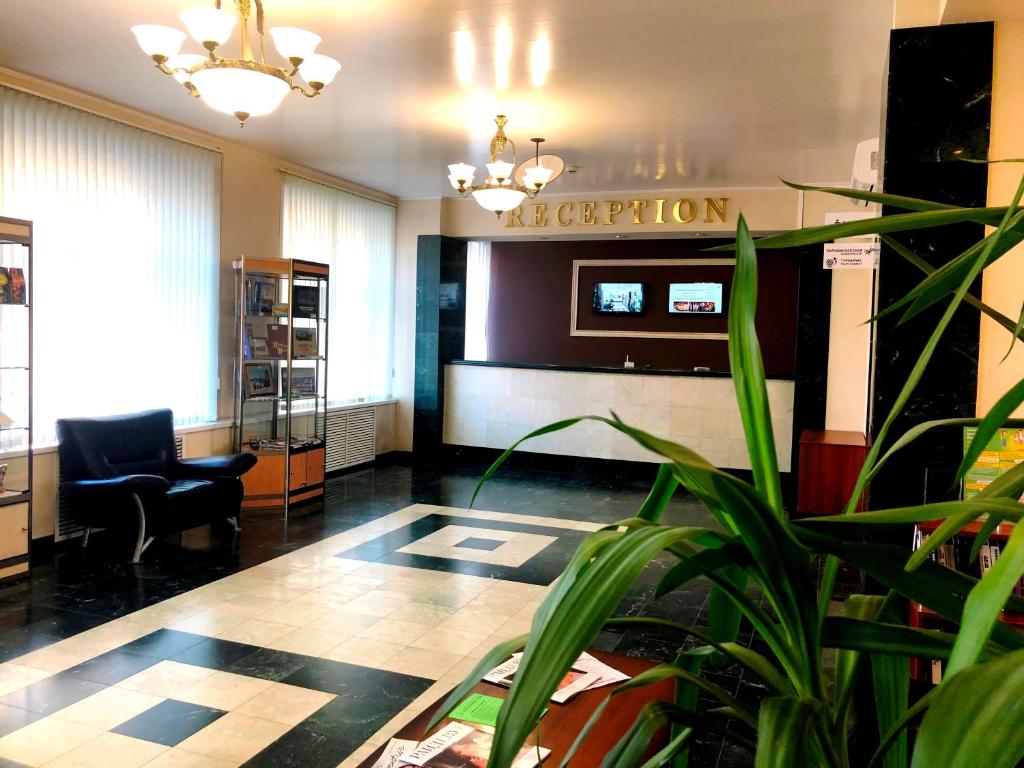 a lobby with a reception desk and a plant at Hotel Vologda in Vologda