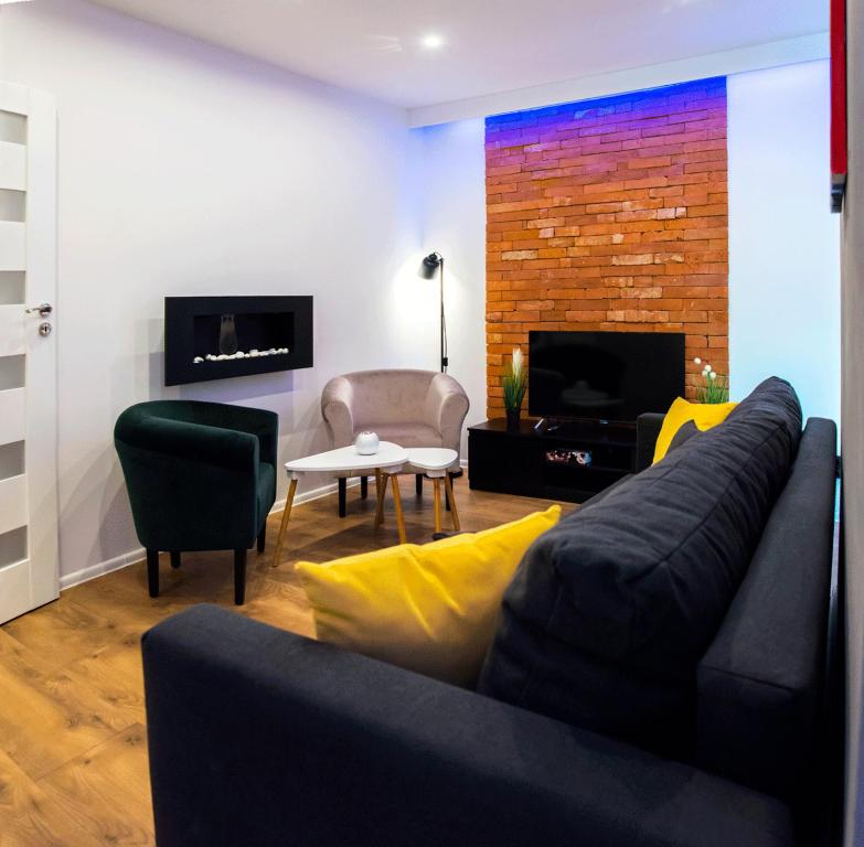 Apartament Gosia في نيسا: غرفة معيشة مع أريكة وتلفزيون
