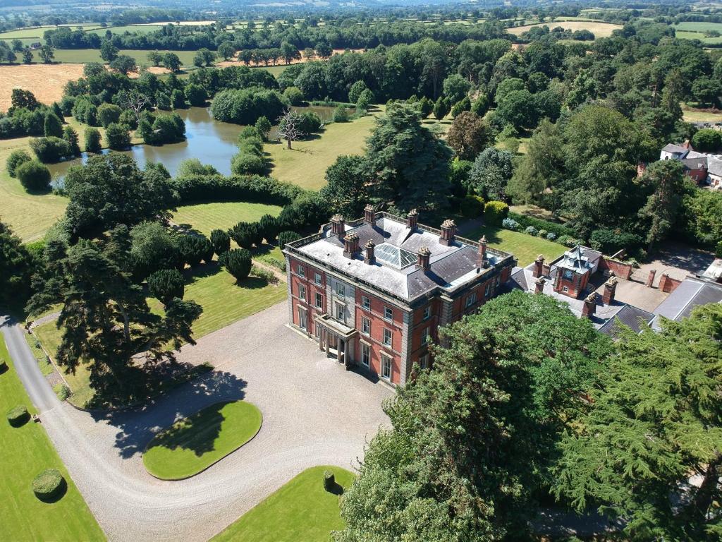 an aerial view of a large house with a river at Netley Hall in Shrewsbury