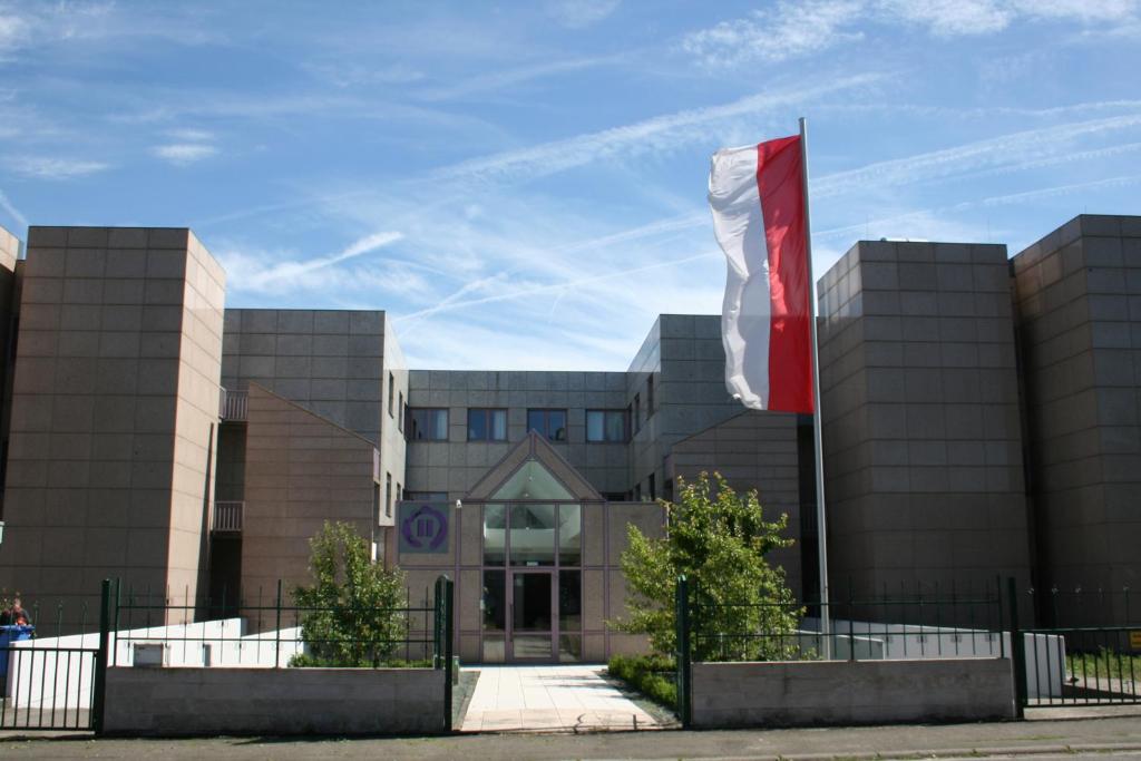 un edificio con una bandera roja delante de él en Hotel Pause, en Hofheim am Taunus