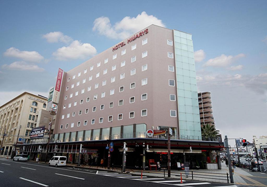 een groot gebouw in een stadsstraat met bij Hotel Hillarys in Osaka