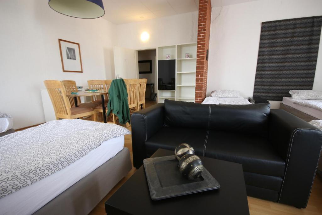 a bedroom with a bed and a couch and a table at Moderne Studio Apartments und 120qm Wohnungen in Oberhausen, ideal für Geschäftsreisende und Monteure in Oberhausen