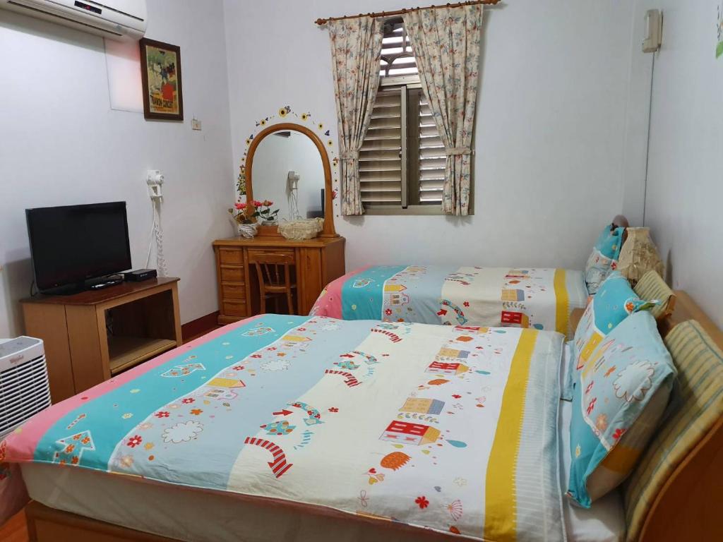 a bedroom with two twin beds and a mirror at Yilan Xiang Feng Homestay in Wujie