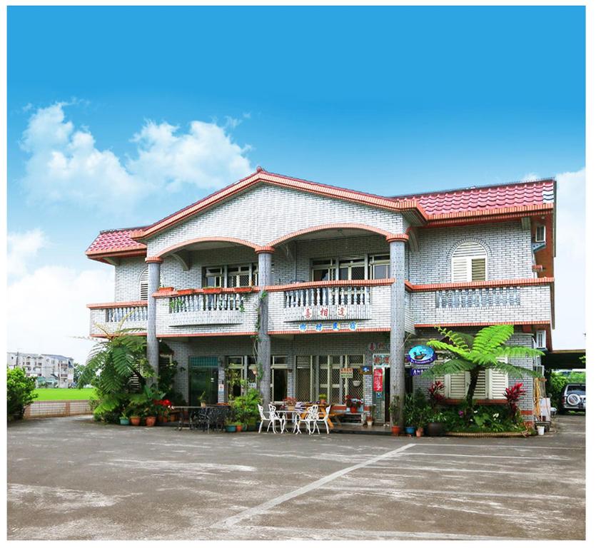 a large building with tables and chairs in a parking lot at Yilan Xiang Feng Homestay in Wujie