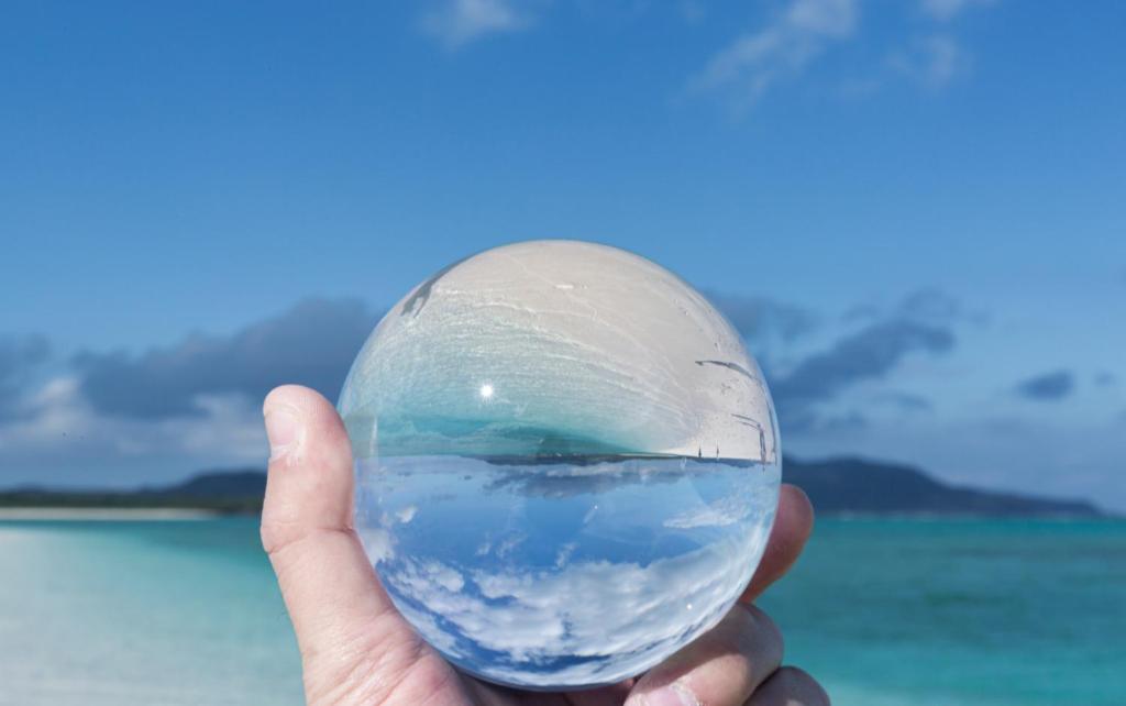 a hand holding a glass ball with the ocean in it at Flat Peace Chair House #205 in Fuzuchi