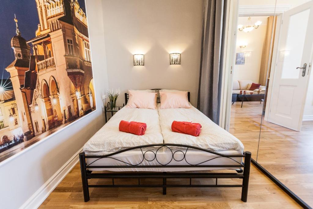 a bedroom with a bed with two red pillows on it at Vintage Podzamcze Apartment in Krakow