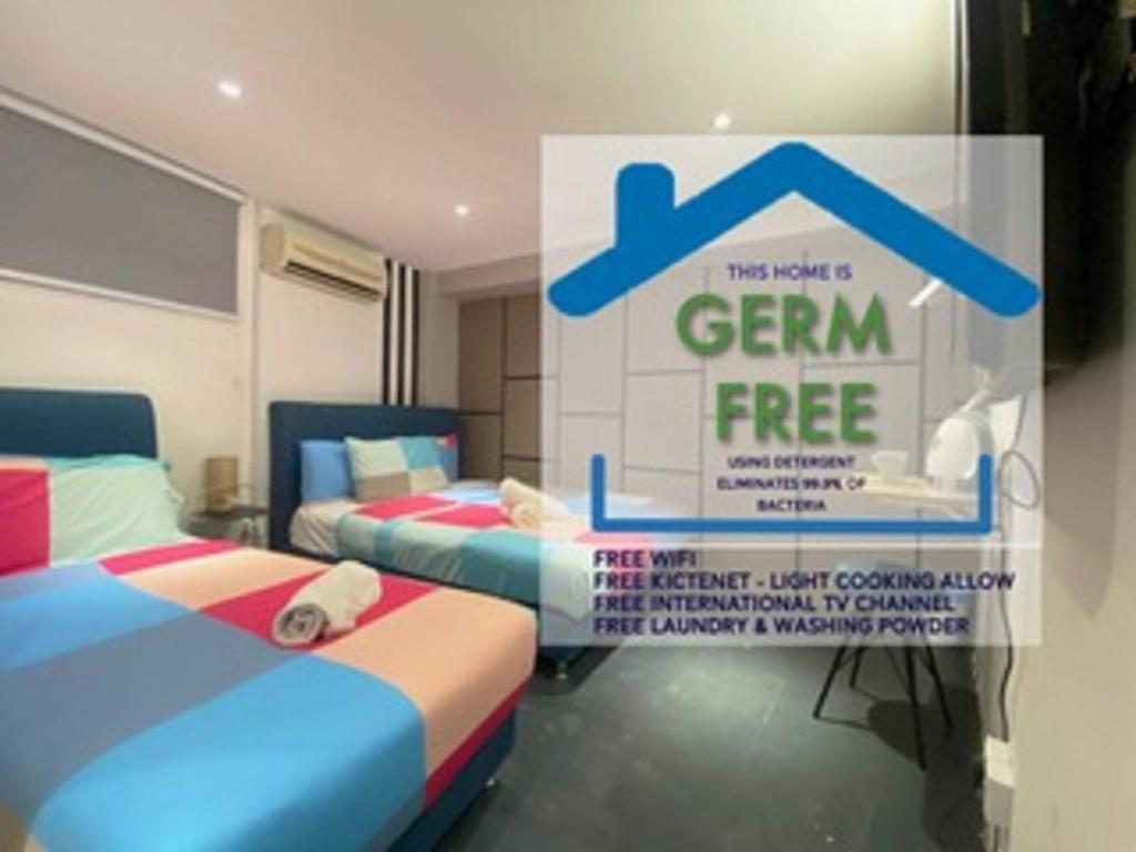 a room with two beds and a sign that says gem free at Omni Suites Hotel Bukit Bintang in Kuala Lumpur