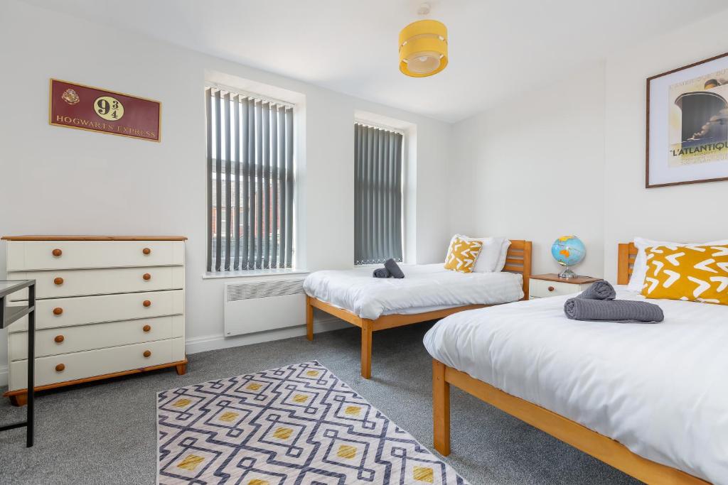 a bedroom with two twin beds and a dresser at Heritage House Apartments - Blackpool Resort Collection in Blackpool