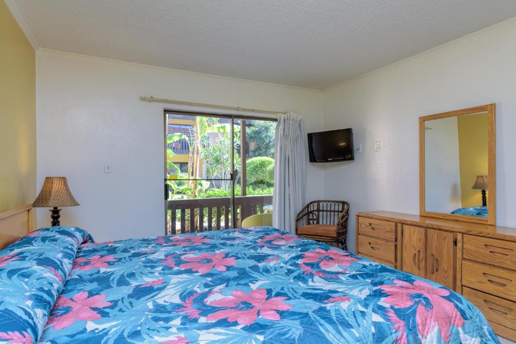 Schlafzimmer mit einem Bett, einem Spiegel und einem Fenster in der Unterkunft Tiki 157 in South Padre Island