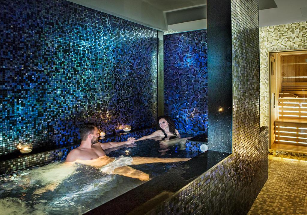 two people in a bath tub with blue tiles at Hotel Continental in Sorrento