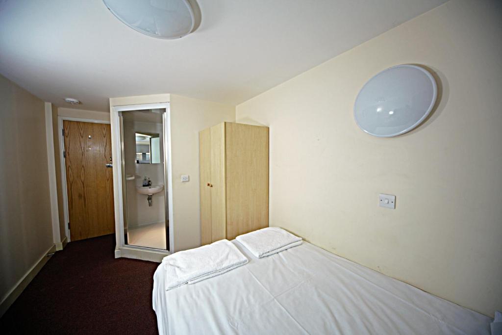 ブラッドフォードにあるTrigg Hallのベッド1台と壁に2つの照明が備わる客室です。