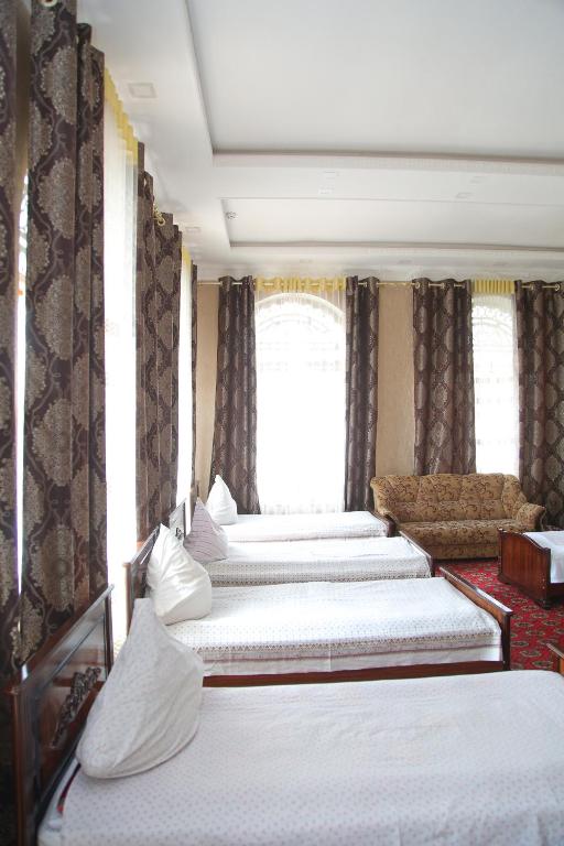a row of four beds in a room at Gulsara hostel in Samarkand