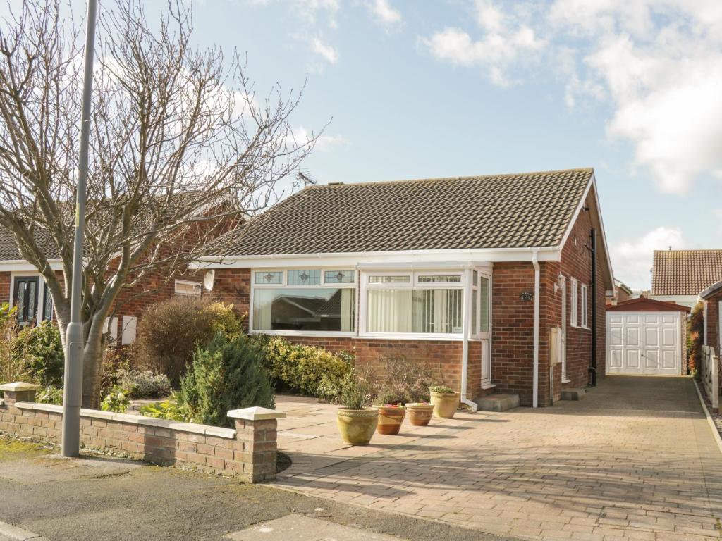 a brick house with a window and a driveway at Arbour Retreat in Filey
