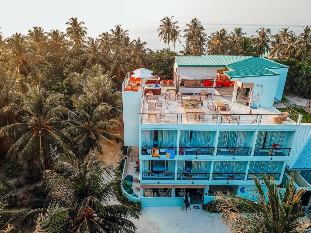 an aerial view of a blue building on the beach at Bliss Dhigurah in Dhigurah