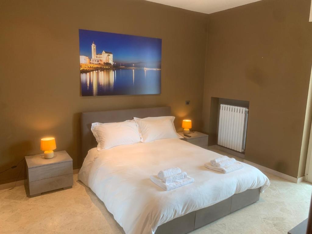 een slaapkamer met een bed met 2 lampen en een schilderij aan de muur bij Sparano Top Class 8 in Bari