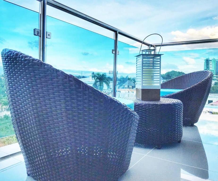 2 sillas de mimbre en la parte superior de un balcón en Modern 3 Bedroom Apt with Wifi and AC Near Airport and Major Areas, en Santiago de los Caballeros