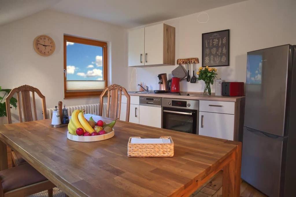 uma cozinha com uma mesa de madeira com uma taça de fruta em Ferienwohnung “Mount Meißner” em Germerode