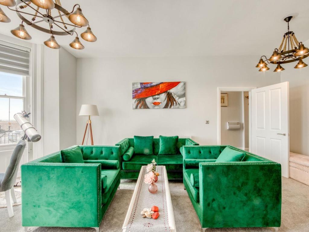 uma sala de estar com um sofá verde e uma mesa em Lovely Apartment Near Town Center em Folkestone