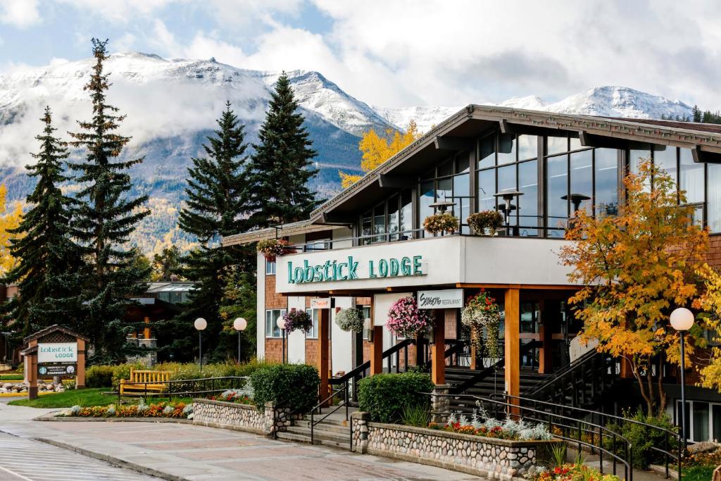 a building with a sign that reads british lodge with mountains in the background at Lobstick Lodge in Jasper