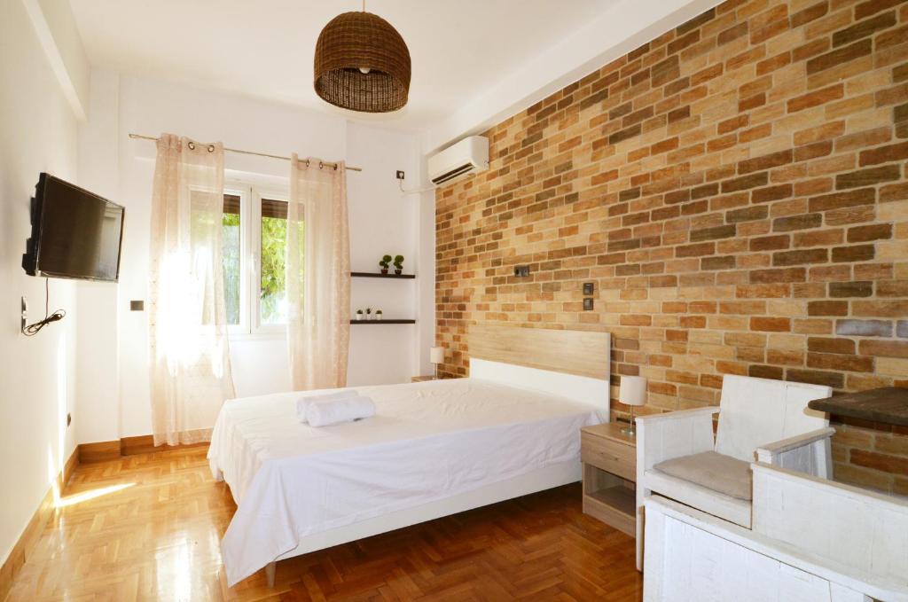 um quarto com uma cama e uma parede de tijolos em A modern rustic cosy apartment at the foot of Mount Lycabettus em Atenas