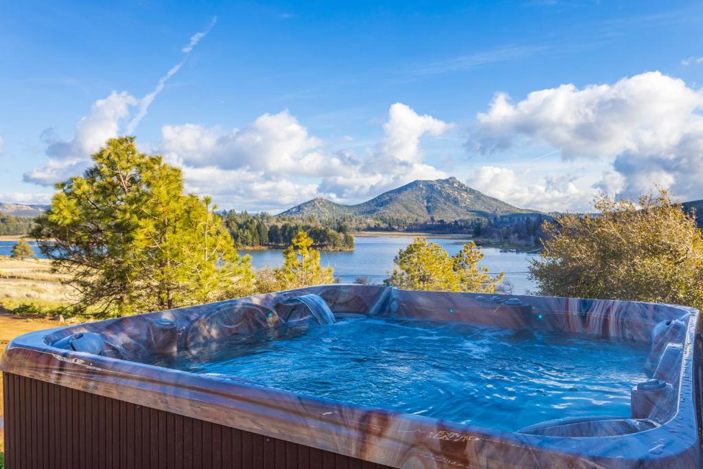 a hot tub with a view of a lake and mountains at Quiet Mind Mountain Lodge, Retreat & Spa in Julian