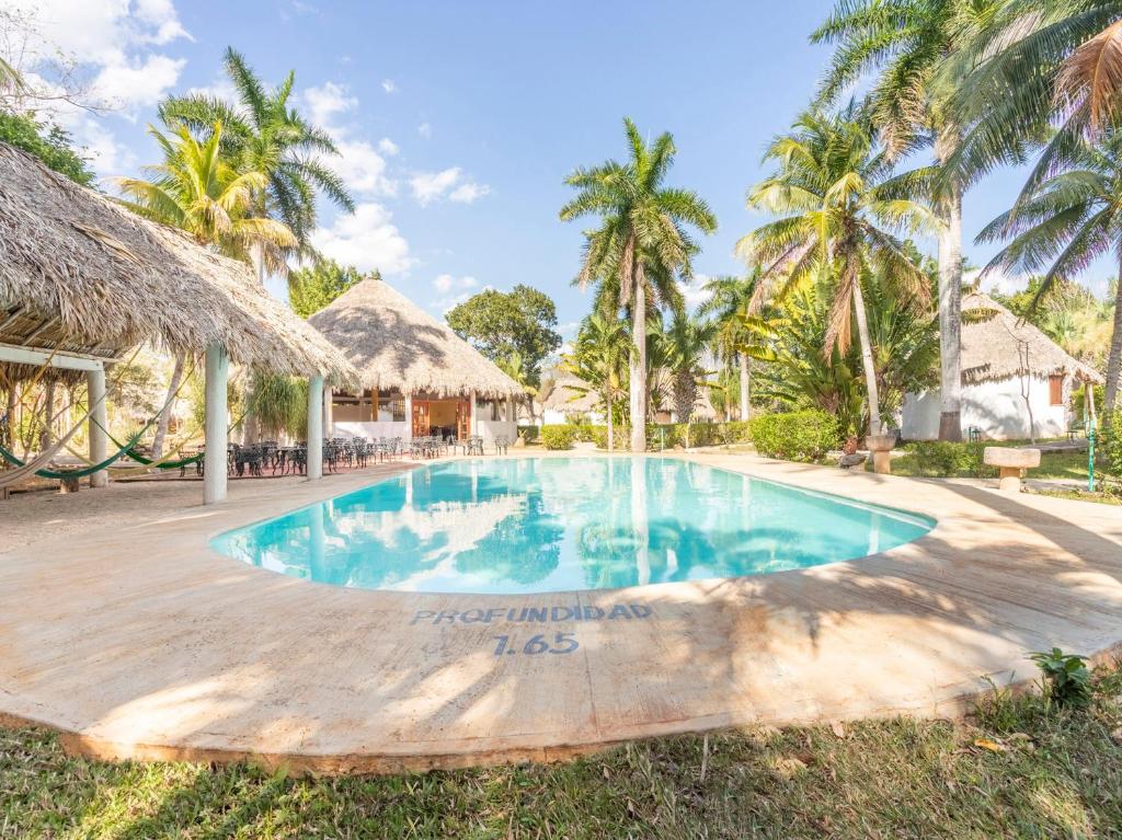 - une piscine dans un complexe avec des palmiers dans l'établissement Hotel Villas del Ángel, à San José