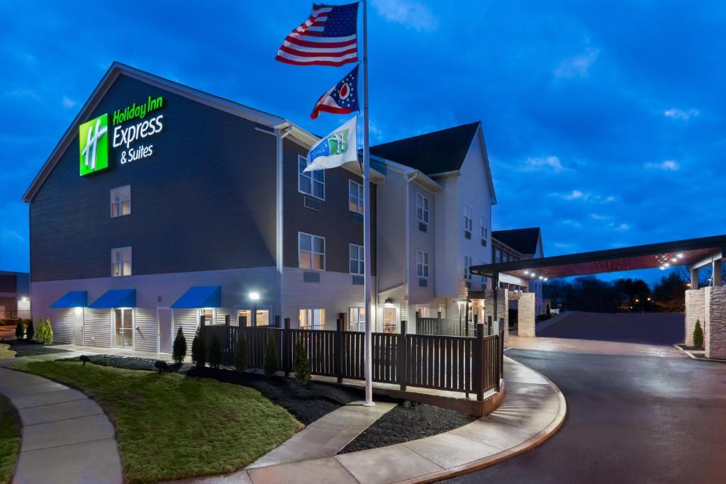 un hôtel avec deux drapeaux devant un bâtiment dans l'établissement Holiday Inn Express & Suites - Columbus Airport East, an IHG Hotel, à Columbus