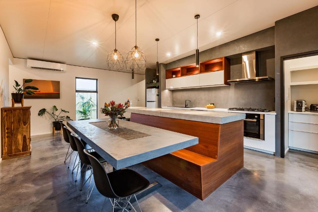 a kitchen with a long island with a table and chairs at Diamante in Dunsborough