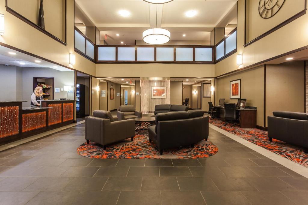 a lobby with a waiting area with chairs and a bar at Holiday Inn Express & Suites Rapid City by IHG in Rapid City