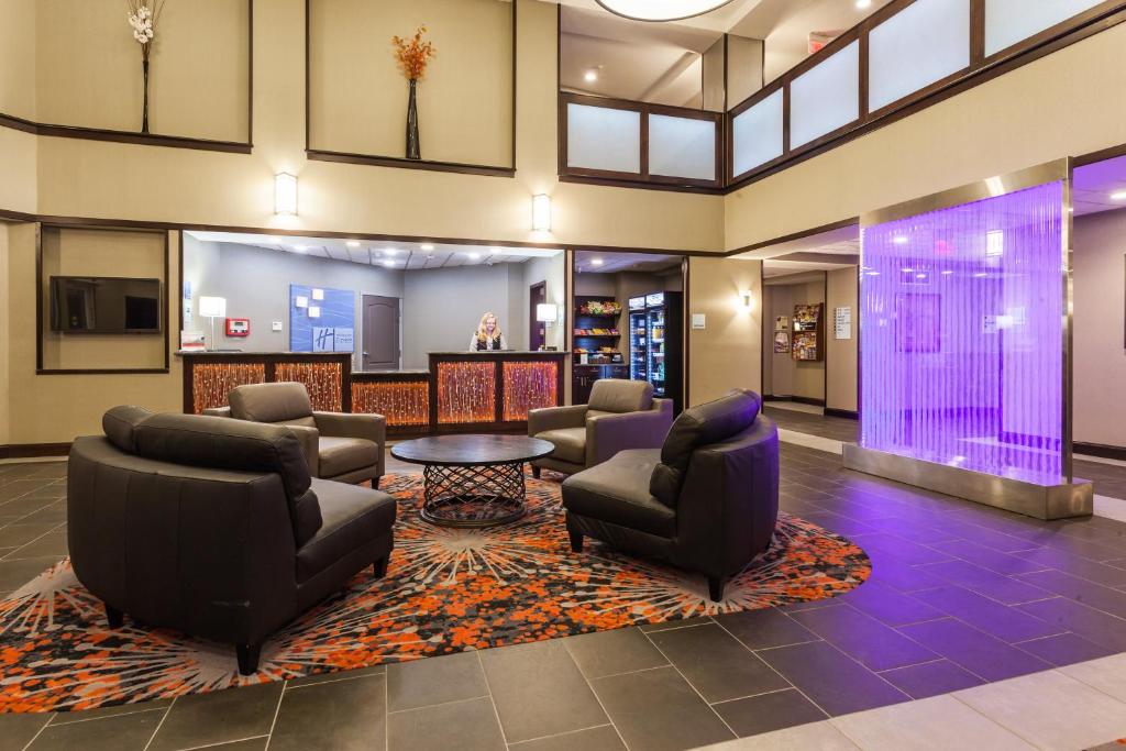 a lobby with couches and chairs and a table at Holiday Inn Express & Suites Rapid City by IHG in Rapid City