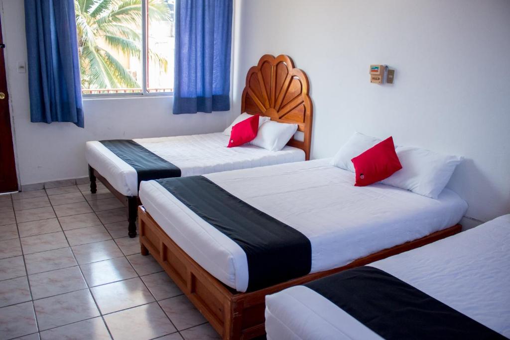 une chambre d'hôtel avec deux lits et une fenêtre dans l'établissement Hotel Adelita, Zihuatanejo, à Zihuatanejo
